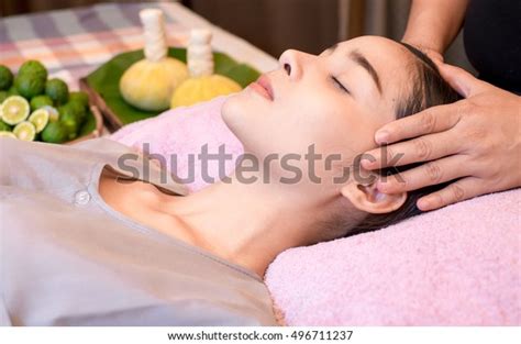 An attractive caucasian blonde woman getting massaged in a spa .